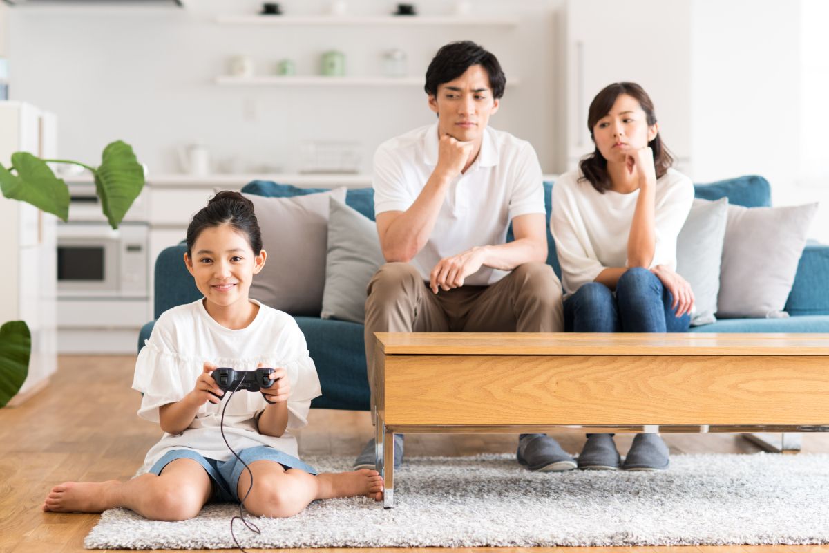 ゲームコントローラーを持って床に座っている女の子