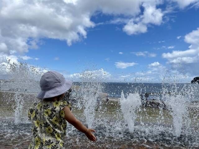 旅行先の海で遊ぶ子ども