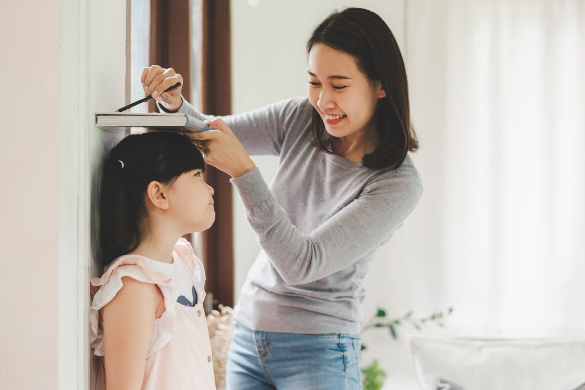 子供の身長を測る母親