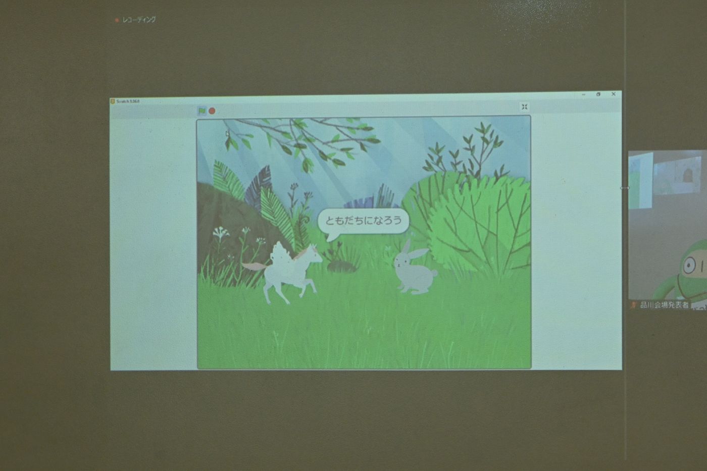 Scratch 3.0で制作されたアニメーション画面。草原の風景の中で、ユニコーンと思われる動物とウサギが描かれ、吹き出しで『ともだちになろう』というセリフが表示されているシーン。
