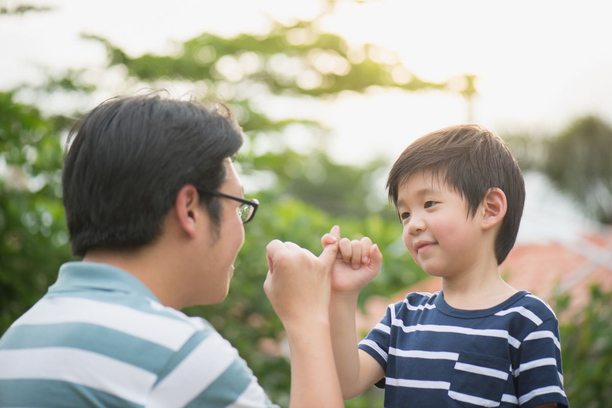 父と息子が指切りをしている