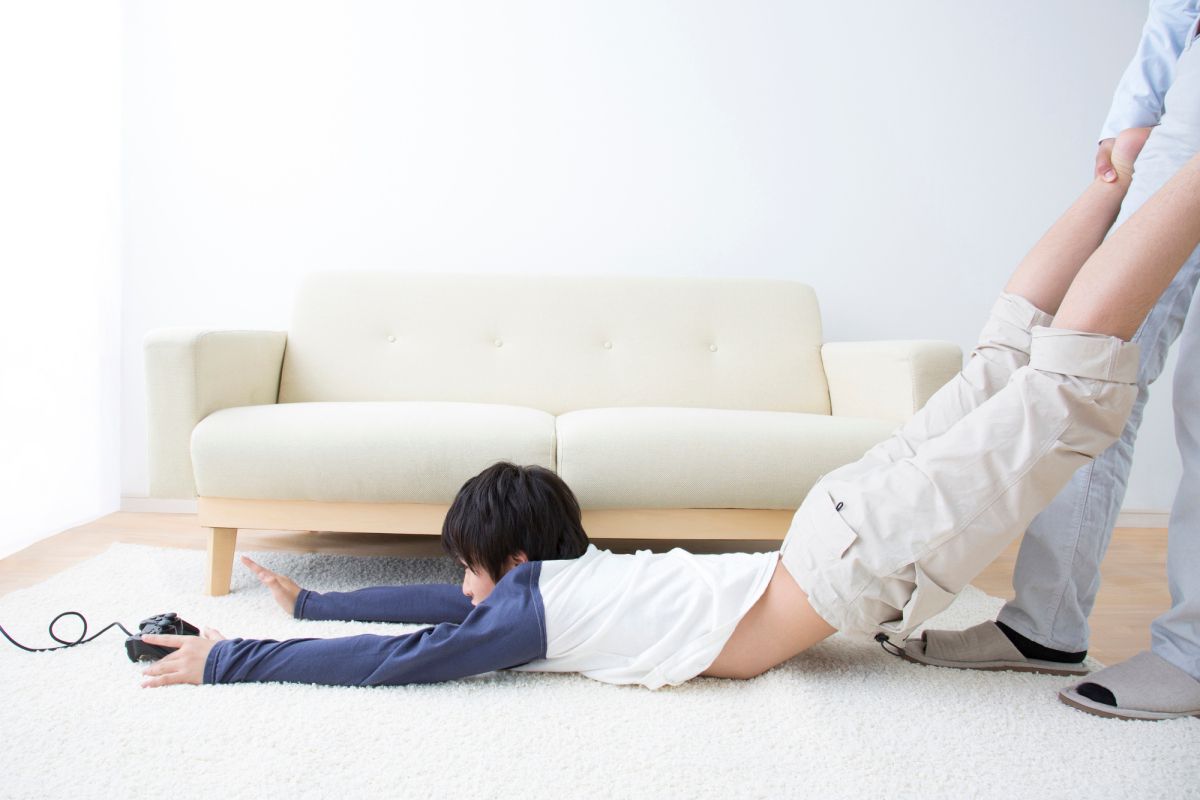 ソファの前の床に横たわっている男の子