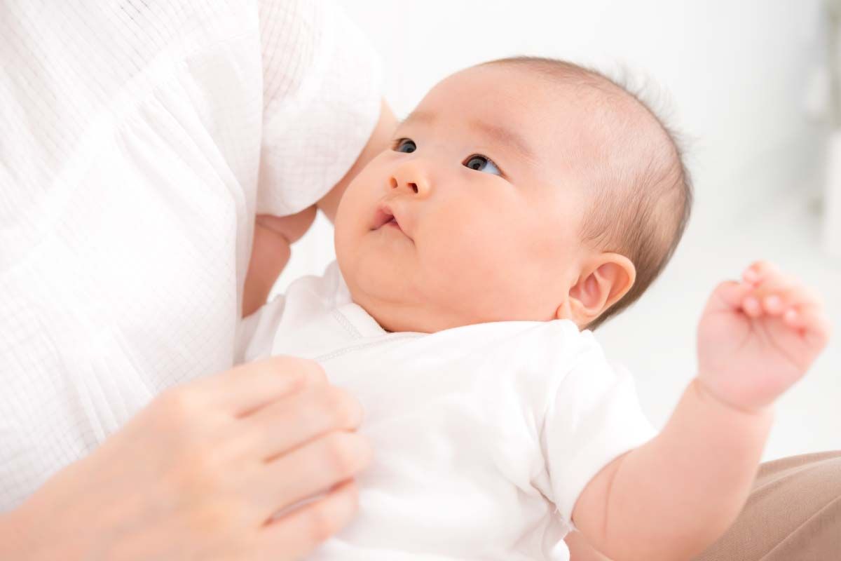 女性が腕に赤ちゃんを抱えています