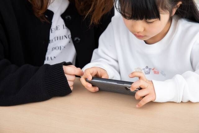 親子でスマホで動画を見る光景