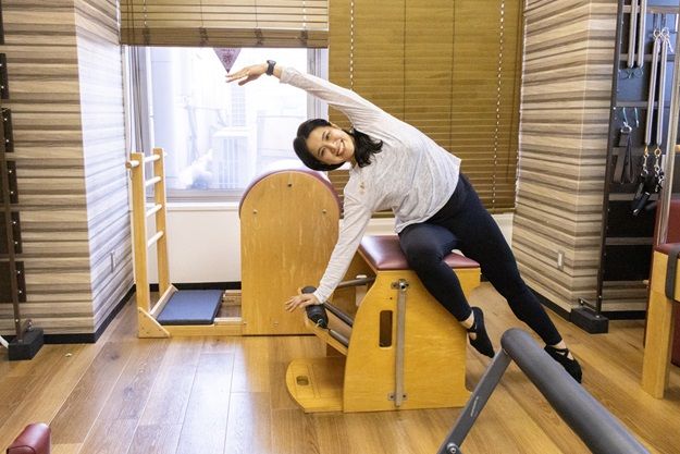 女性がピラティスマシンの上に座っています。