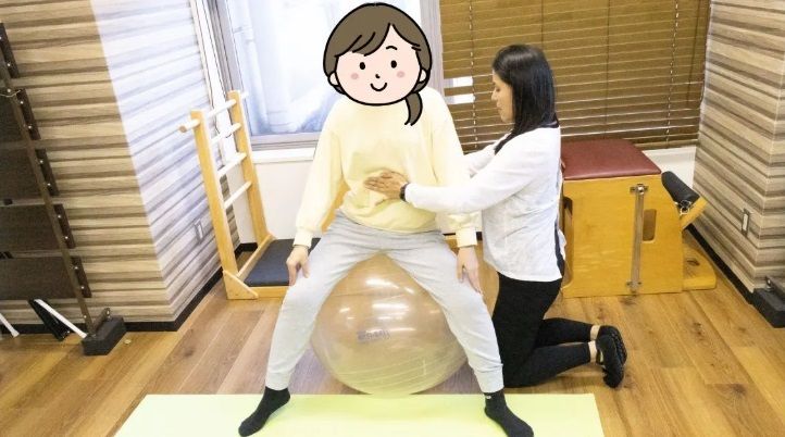女性が男性の足にボールを置いている