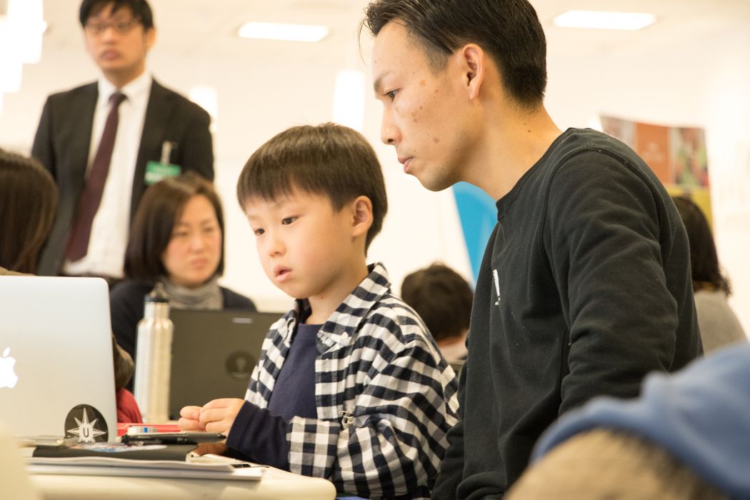 男性と男の子がラップトップを見ています
